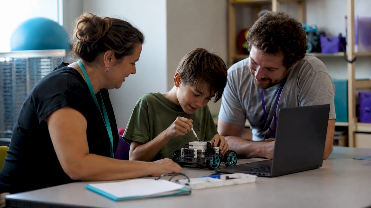 Children assembling STEAM hands-on kits on classroom floor