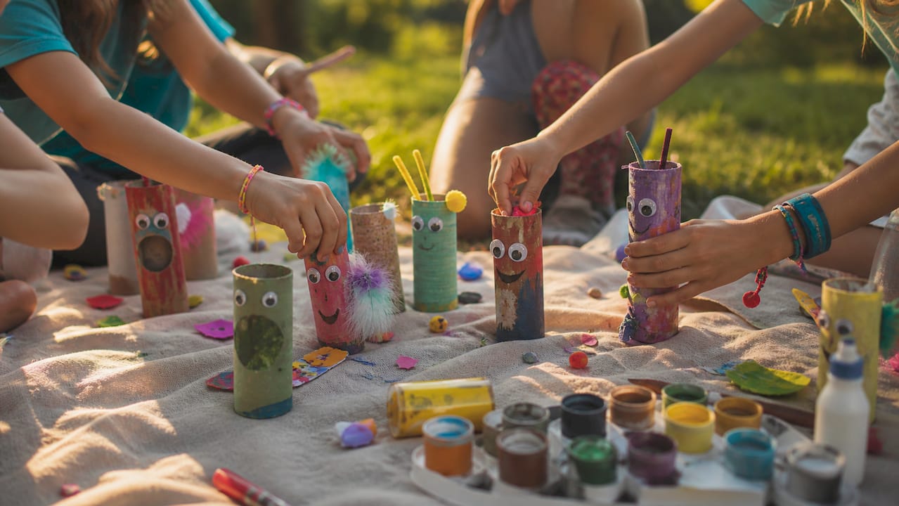 Children's hands crafting with toilet paper rolls