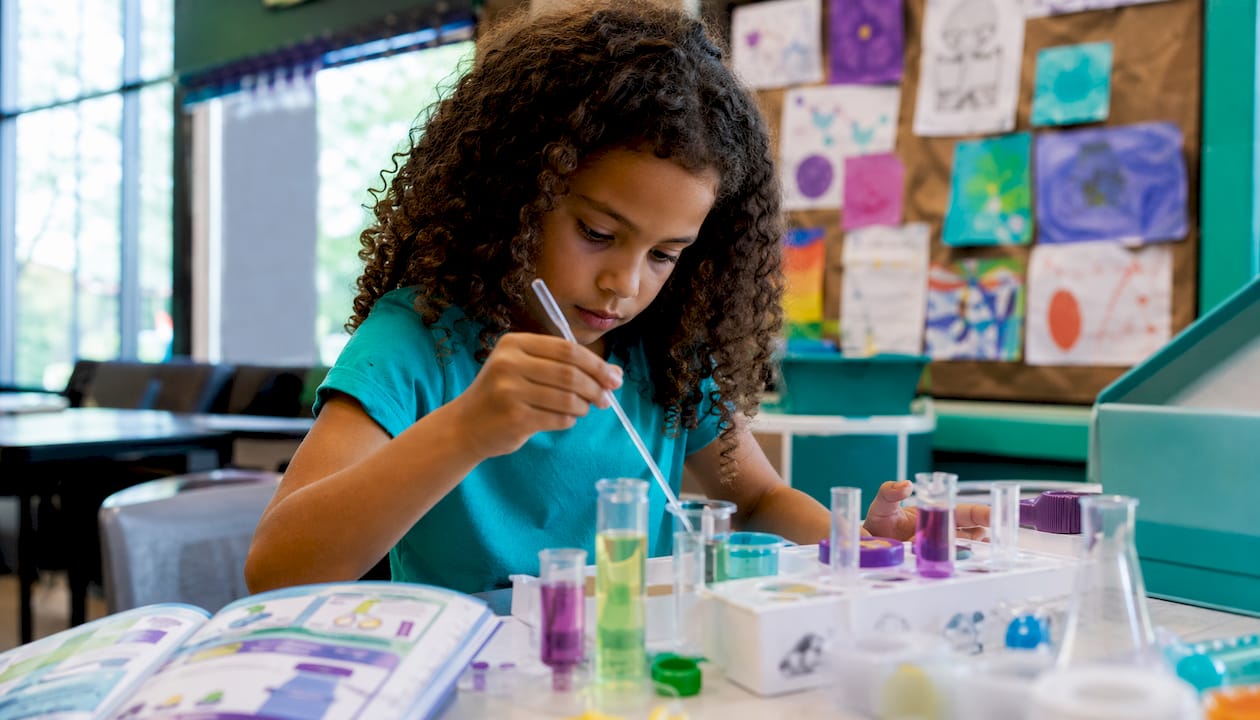 Child assembling colorful science kit at home