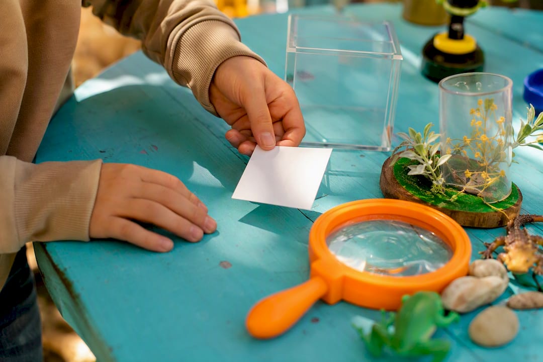 Child hands placing exit ticket card on table
