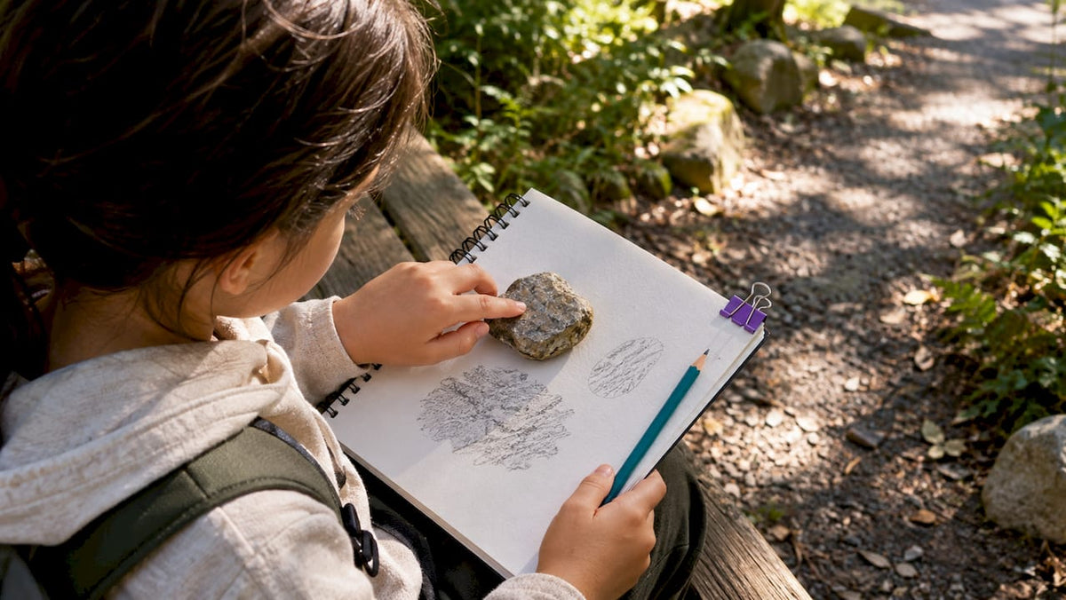 Child recording observations of a rock
